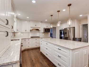 Newly remodeled white kitchen, featuring modern appliances and ample counter space.